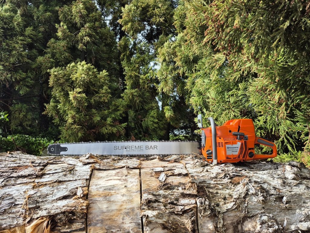 supreme pro bar pictured fitted to a husqvarna chainsaw, sitting on a log.